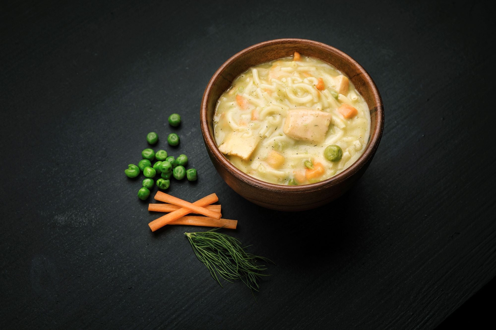 Bowl of Real Turmat Creamy Salmon with  pasta on a dark surface