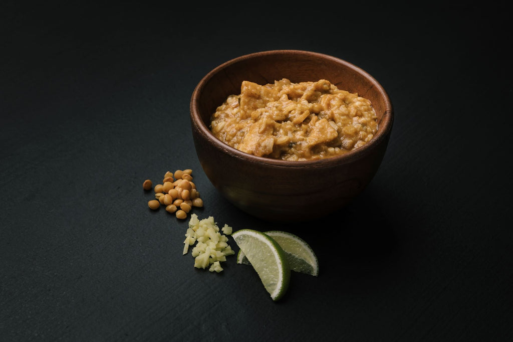 Bowl of prepared Reall Turmat Tikka Masala with ingredients on a dark surface