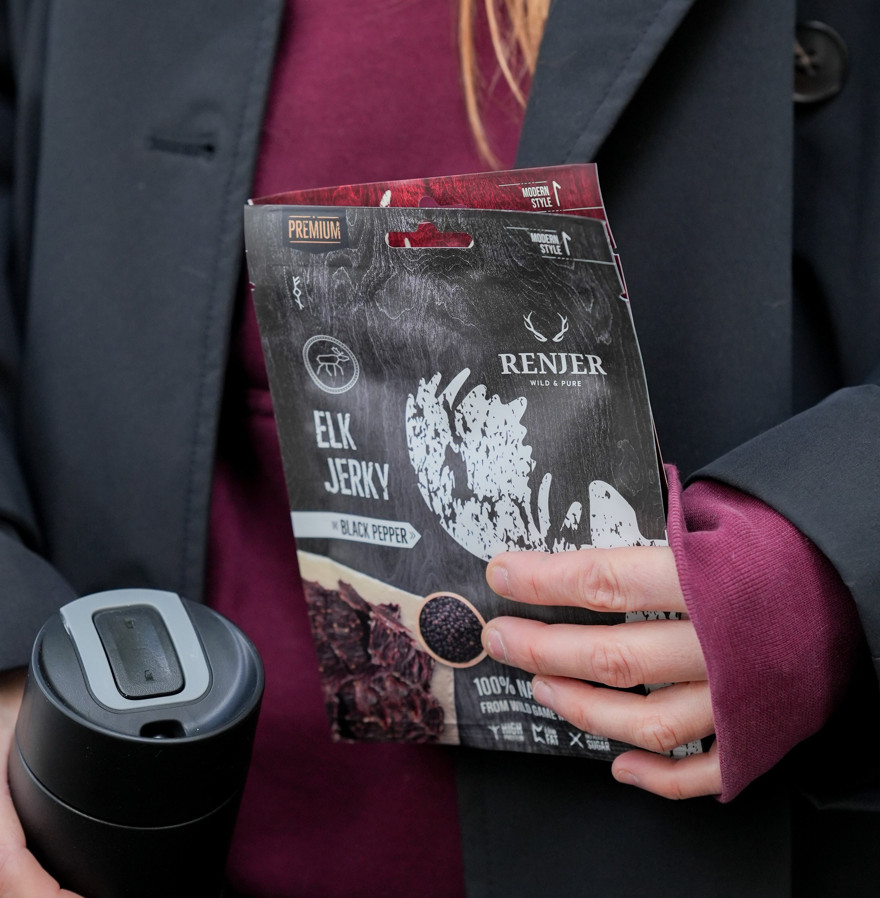 Person holding a package of Renjer Elk Jerky with a black pepper flavor