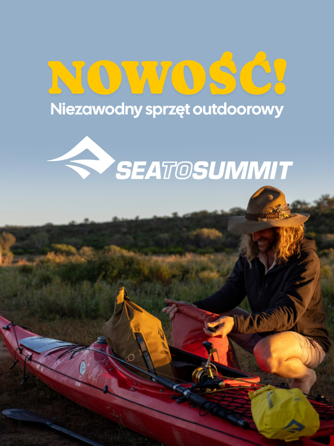 Osoba przygotowująca kajak z wyposażeniem marki Sea to Summit na tle malowniczego krajobrazu.