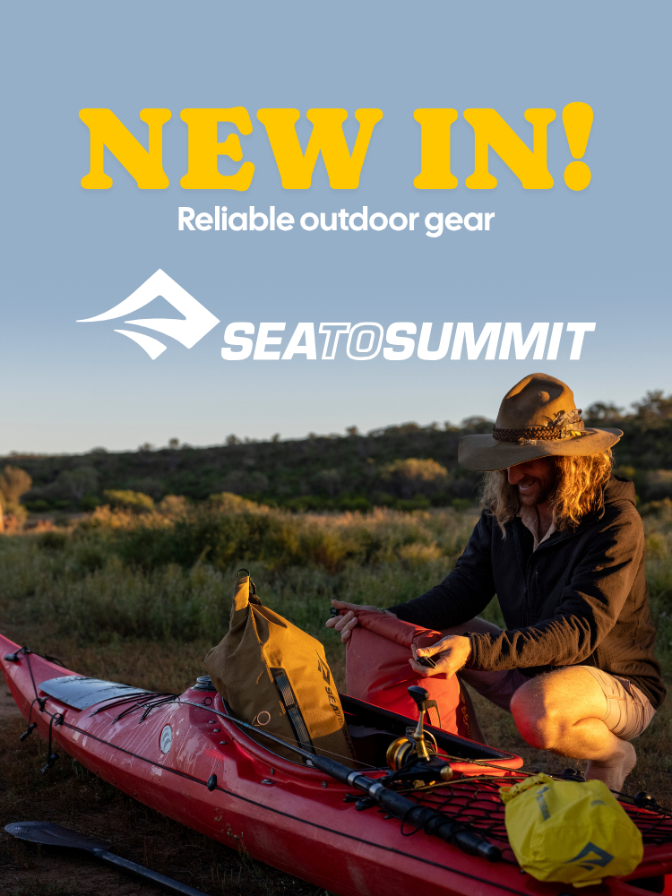 Person preparing outdoor gear next to a kayak with Seatosummit branding.